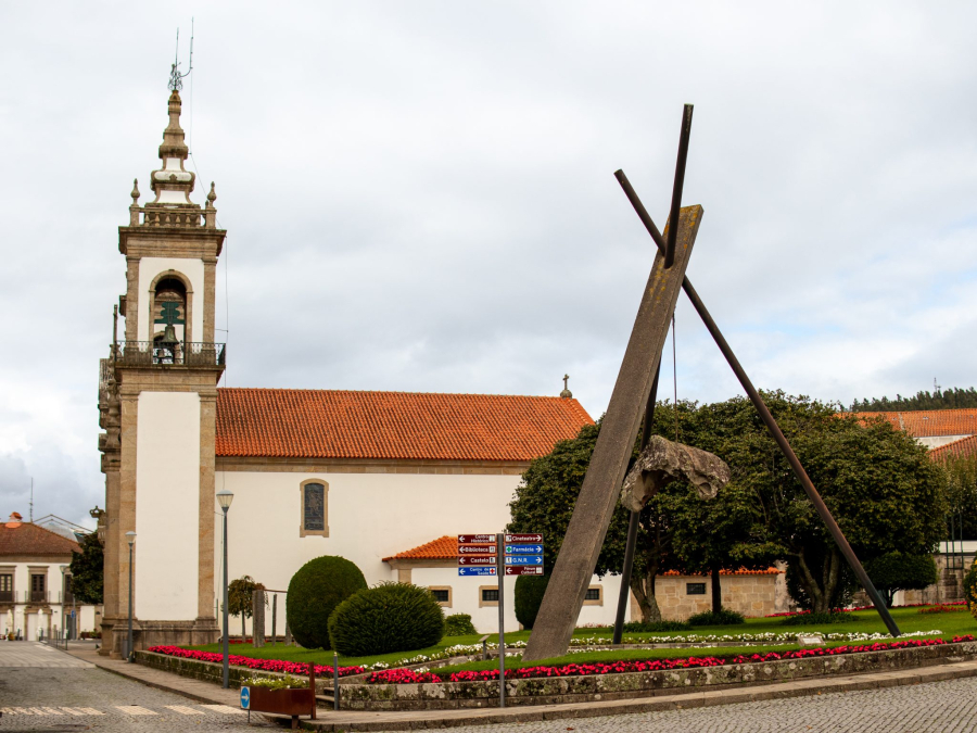 Historic church in Vila Nova de Cerveira, Portugal, with contemporary art installations in the foreground, blending tradition and modern creativity